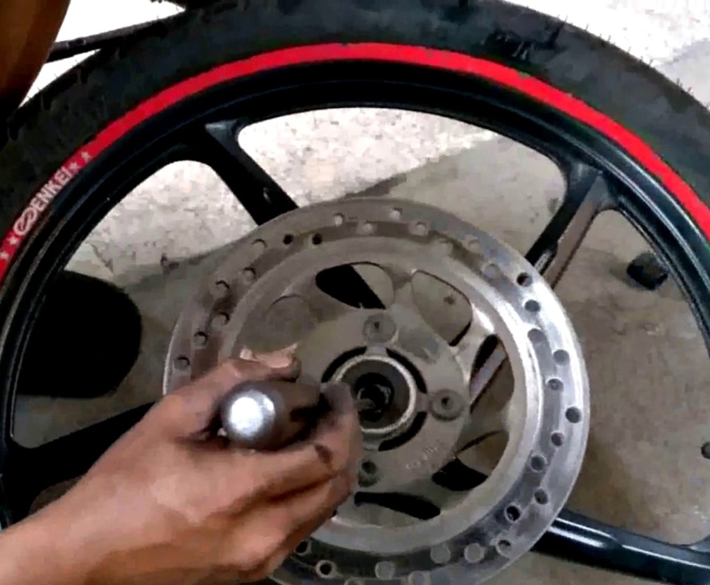 Proses merawat bearing roda motor. 