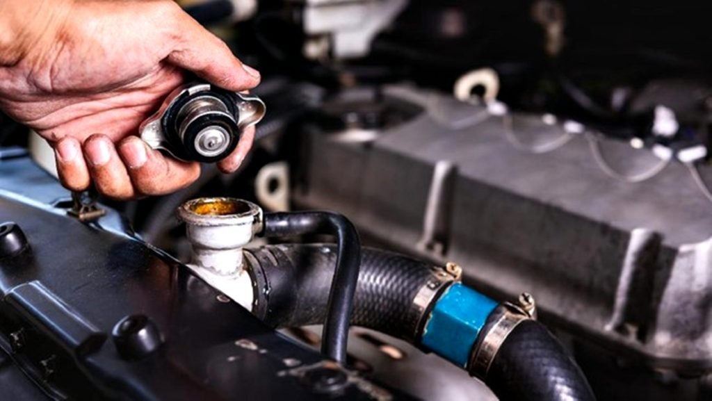 Ilustrasi membuka tutup radiator ketika mesin overheat.