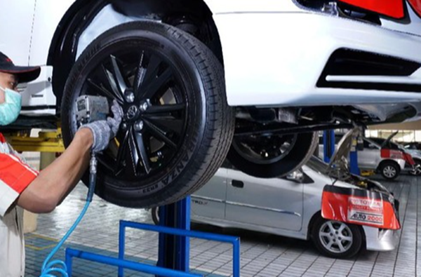Memasang velg karbon pada mobil.
